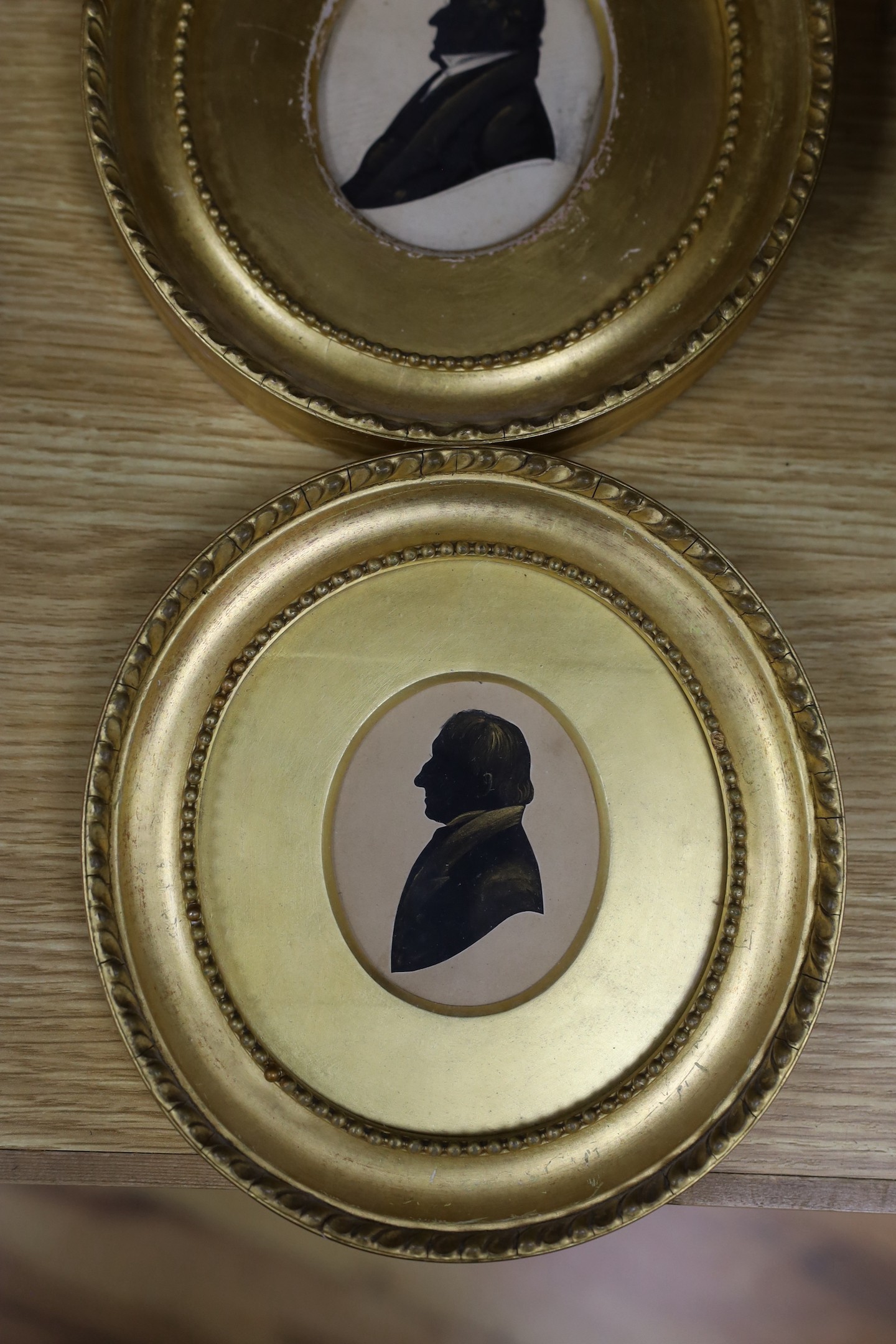 Victorian School, cut paper heightened with bronze, Silhouette of a gentleman, 8 x 6.5cm, with two similar silhouettes